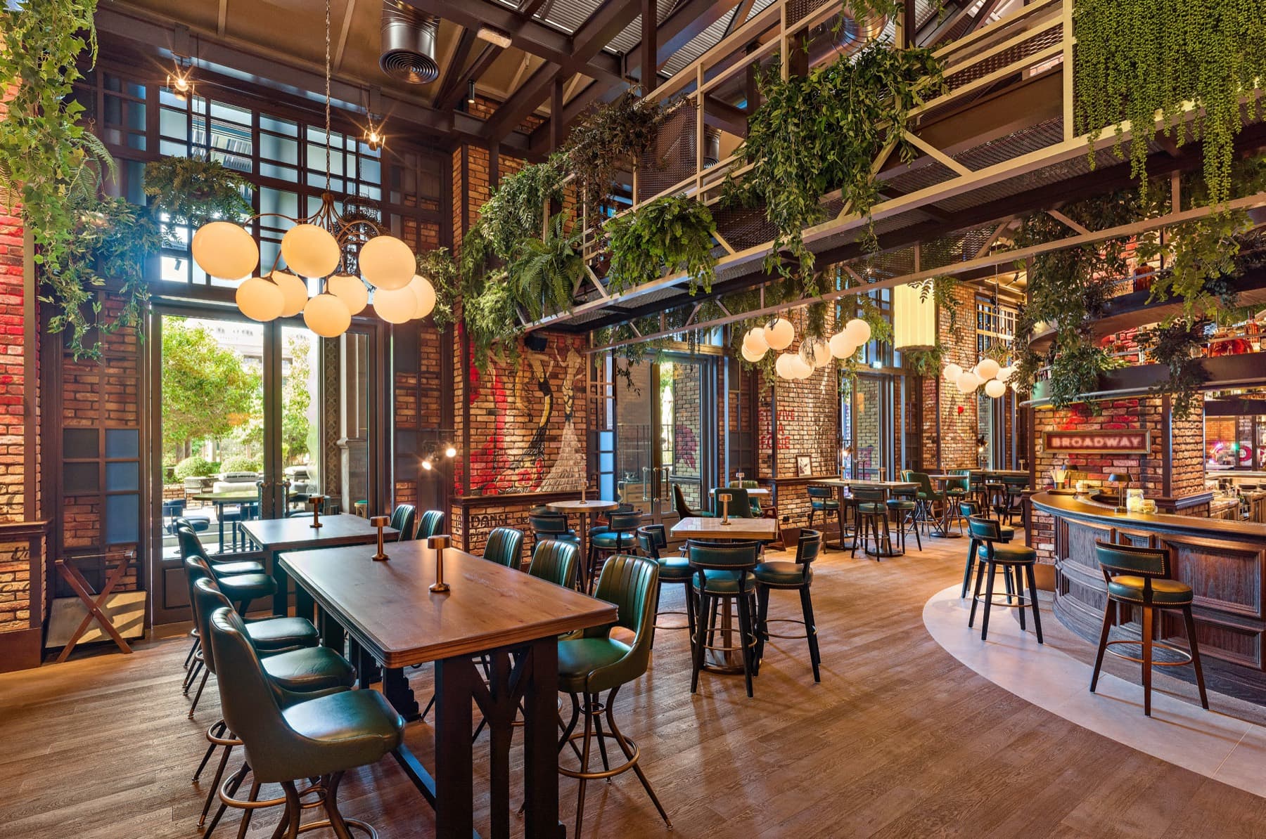 Broadway restaurant interior with hanging plants and brick walls